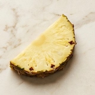 Fresh pineapple wedge on marble
